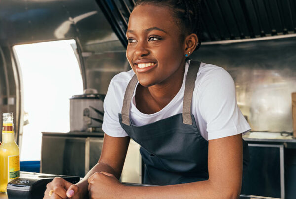Food Truck Insurance - Woman at Food Truck Counter Ready to Serve Food and Take Orders from Customers